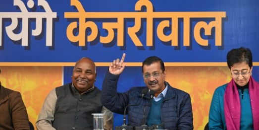 "Arvind Kejriwal speaking at a public event, addressing Delhi's transport and education policies."