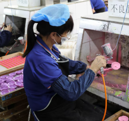 Factory workers painting toy parts in a Shaoguan, China facility owned by a US company.