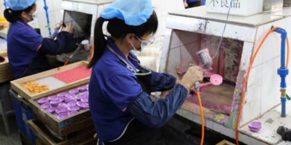 Factory workers painting toy parts in a Shaoguan, China facility owned by a US company.