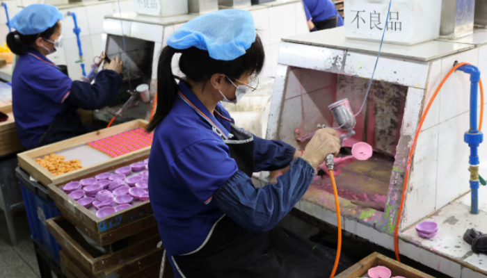 Factory workers painting toy parts in a Shaoguan, China facility owned by a US company.